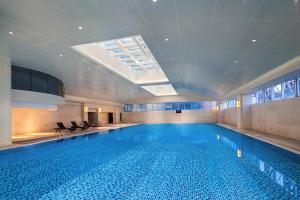 a large swimming pool in a building with a large swimming pool at Park Inn by Radisson Wenzhou Longwan International Airport Wanda Plaza in Xingqianjie