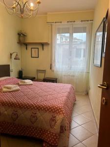 a bedroom with a bed with a redspread and a window at La casa di Gioia in Florence