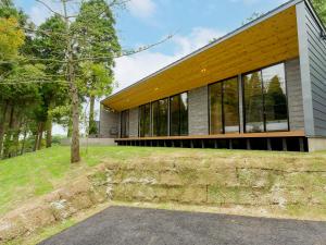a house with glass windows on the side of it at Rakuten STAY VILLA Aso Kurokawa in Minamioguni