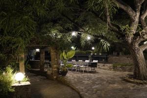 a patio with a table and chairs at night at EXQUISITE PRIVATE LUXURY SUITE WITH KING BED at BOKMAKIERIE VILLAS in Windhoek