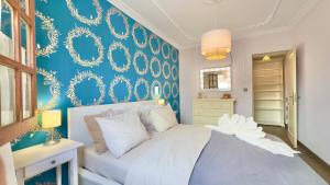 Un dormitorio con una cama blanca con una pared azul. en Exclusive Villa Valencia - Denia Els Poblets, en Els Poblets 36 fotos más