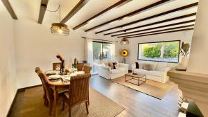 a living room with a table and chairs and a couch at Exclusive Villa Valencia - Denia Els Poblets in Els Poblets