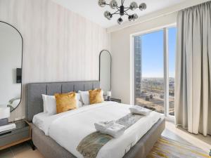1 dormitorio con 1 cama grande y ventana grande en Sophisticated and Trendy 2BDR In Forte Downtown en Dubái