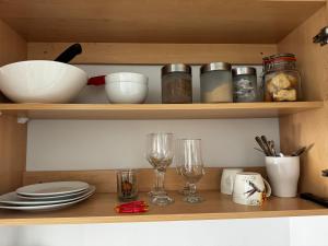 a wooden shelf with dishes and glasses on it at Tortoise Retreat in Langebaan
