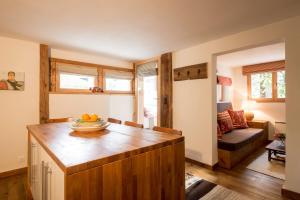 a kitchen with a wooden island with a bowl of fruit on it at La Ruinette - Cosy 1 Bed, 300m From Cable Car in Le Châble