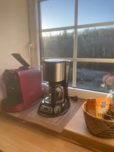 a coffee maker sitting on a counter next to a window at Moulin de brezal et étang à 20 minute de la mer in Plounéventer