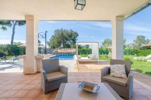 un patio con sillas, una mesa y una piscina en YourHouse Romani Villa en Muro