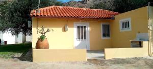 a small yellow house with a plant in a vase at Despina's House in Sitia