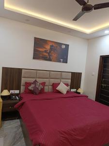 a bedroom with a large bed with a red bedspread at Narayan Palace- Luxury Homestay in Varanasi