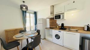 a kitchen with a table with chairs and a sink at Appartement Citadella 1 Calvi in Calvi +22 photos