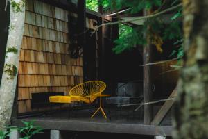 una casa con una mesa amarilla y sillas en una terraza en Kussharoko Sauna Club, en Teshikaga