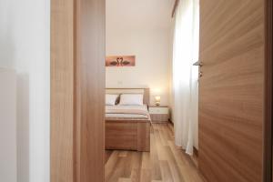 a small bedroom with a bed and a wooden door at Timea A2 in Zambratija