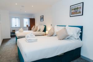 ein Schlafzimmer mit zwei Betten und ein Wohnzimmer in der Unterkunft George House Modern Apartments by VICHY in Hull
