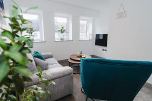 een woonkamer met een bank en een stoel bij George House Modern Apartments by VICHY in Hull