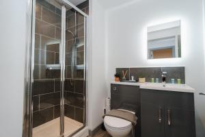 a bathroom with a shower and a toilet and a sink at George House Modern Apartments by VICHY in Hull