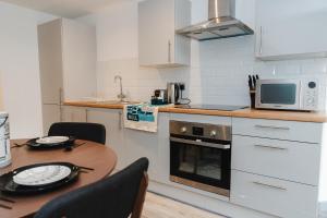 a small kitchen with a table and a microwave at George House Modern Apartments by VICHY in Hull
