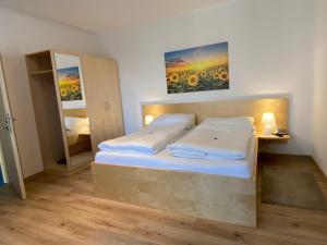 Schlafzimmer mit einem Bett und einem Spiegel in der Unterkunft Pension Peterhof in Mörbisch am See