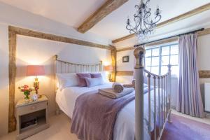 una camera con letto e lampadario a braccio di Charlie's Cottage a Ludlow