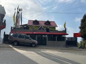 uma SUV estacionada em frente a um edifício em Kunsang Homestay em Ghum