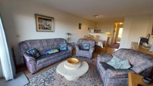 un salon avec deux canapés et une table dans l'établissement Residentie Koksijde promenade, à Coxyde