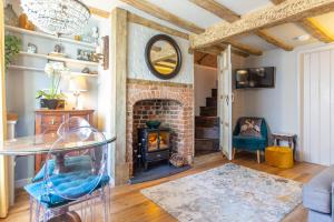 a living room with a brick fireplace and a table at Charlie's Cottage in Ludlow