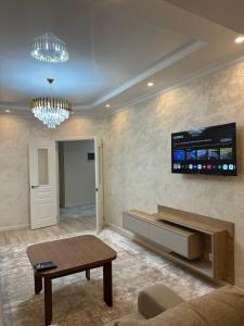 ein Wohnzimmer mit einem Sofa und einem TV an der Wand in der Unterkunft Manolo apartment’s in Bischkek