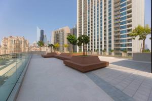 a row of benches with trees on a building at Sunny Downtown Retreat- Direct access to Dubai Mall in Dubai