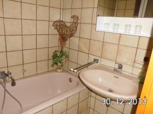 a bathroom with a bath tub and a sink at Gästehaus Auhagen in Auhagen