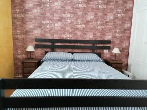 a bedroom with a bed and a brick wall at Abades Chalet in La Listada