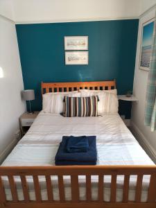 - une chambre avec un grand lit et un mur bleu dans l'établissement Ashton Holiday Flats Seaviews, à Bridlington