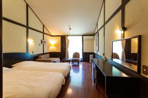 a hotel room with two beds and a flat screen tv at Kussharoko Sauna Club in Teshikaga