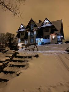 Una casa en la nieve por la noche en Na Skarpie en Białka Tatrzanska