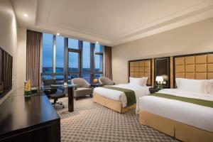 a hotel room with two beds and a desk at Holiday Inn Beijing Airport Zone by IHG in Shunyi +61 photos