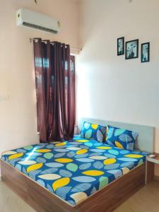 a bedroom with a bed with a blue and yellow comforter at Shiv Shakti Palace in Rīngas