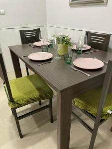a wooden table with plates and wine glasses on it at KAIROS HOME y Garaje , Algemesí Home in Algemesí