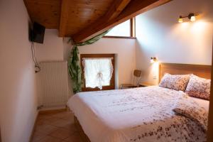 a bedroom with a bed and a window at Residenza Garibaldi in Molveno