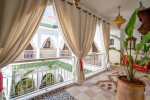 BÔ Riad Boutique Hotel & Spa في مراكش: غرفة مع نافذة كبيرة وشرفة
