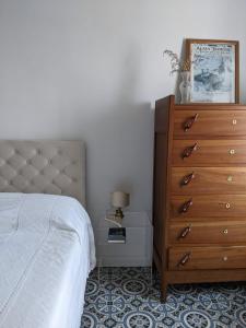 een slaapkamer met een bed en een dressoir met een lamp bij Casa panoramica 