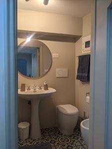 een badkamer met een wastafel, een toilet en een spiegel bij Casa panoramica 