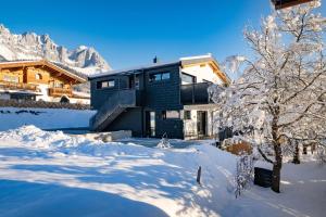 una casa nella neve con montagne sullo sfondo di Mountain Residence a Going