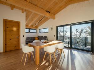 una sala da pranzo con tavolo in legno e sedie bianche di Mountain Residence a Going
