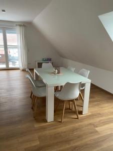 a dining room with a white table and chairs at Ferienwohnung Landhege in Michelfeld