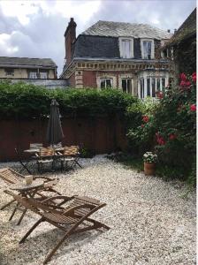 una casa con sombrilla, mesa y sillas en Maison individuelle dans ancienne ecurie, en Rouen