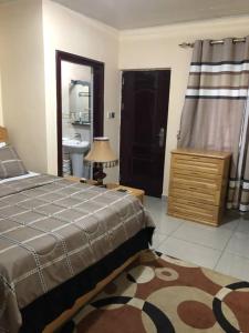 MAYRAH Inn - Your comfortable home from home in Freetown Sierra Leone في Goderich: غرفة نوم بسرير وحمام مع حوض