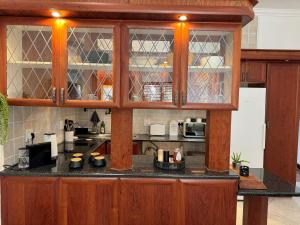 a kitchen with wooden cabinets and a counter top at Wisteria Place@3 Boschdal Rustenburg in Rustenburg