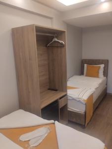 een kleine kamer met 2 bedden en een kast bij Mr Lion Kumkapı Otel in Istanbul