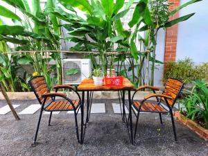 a table with two chairs and a table with plants at Kampot Coco Guest House in Kampot