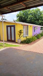 una casa gialla con una porta rossa di BellaMaria a Pretoria