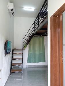 a room with a staircase and a tv in a room at Tiny House Idaman Kuala Terengganu with Private House in Kuala Terengganu