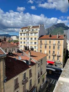 uma vista para uma cidade com edifícios e montanhas em St Bruno - Studio Tropiques  em Grenoble
